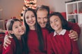 Photo of adorable attractive son daughter dad mom wear red pullovers smiling celebrating christmas hugging indoors house