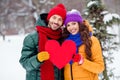 Photo of adorable charming girlfriend boyfriend dressed vests smiling hugging holding red heart walking snow outdoors Royalty Free Stock Photo
