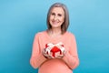 Photo of adorable charming lady dressed coral shirt holding red heart shape present box isolated blue color background Royalty Free Stock Photo