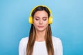 Photo of adorable concentrated focused lady listening meditation quality stereo sound isolated on blue color background