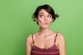 Photo of adorable cute woman wear trendy clothes hmm doubt look empty space isolated on green color background