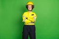 Photo of adorable cute young firewoman dressed yellow uniform helmet arms crossed smiling isolated green color