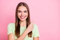 Photo of adorable cute young girl dressed green t-shirt pointing one finger empty space isolated pastel pink color Royalty Free Stock Photo