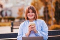 Photo of adorable cute young lady wear blue shirt drinking tea coffee looking modern device outside urban city street Royalty Free Stock Photo