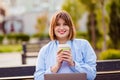 Photo of adorable cute young lady wear blue shirt drinking tea coffee looking modern device outside urban city street Royalty Free Stock Photo