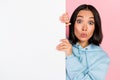 Photo of adorable excited lady wear blue hoodie holding blank billboard empty space isolated pink color background Royalty Free Stock Photo