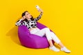Photo of adorable funky lady dressed cowskin shirt sitting bean bag recording vlog empty space isolated yellow color
