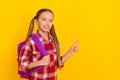 Photo of adorable funny schoolkid dressed plaid shirt pointing empty space isolated yellow color background