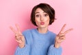 Photo of adorable humorous woman pout lips kiss showing v-sign date boyfriend isolated on pink color background Royalty Free Stock Photo