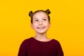 Photo of adorable intelligent minded girl toothy smile look up empty space isolated on yellow color background