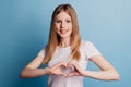 Photo of adorable peaceful serene lady hands show like heart gesture toothy smile on blue background