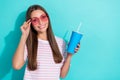 Photo of adorable pretty girl long hairstyle striped t-shirt hold blue paper cup touch pink glasses isolated on Royalty Free Stock Photo