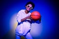 Photo of adorable pretty lady dressed hoodie dark eyewear playing basketball isolated blue color background Royalty Free Stock Photo