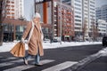 Photo of adorable pretty woman wear beige coat crossing road purchase new year presents outside urban city street Royalty Free Stock Photo