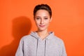 Photo of adorable pretty young lady wear grey sweatshirt smiling isolated orange color background