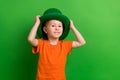 Photo of adorable schoolboy wear leprechaun costume enjoy family saint patrick event isolated on green color background Royalty Free Stock Photo