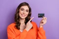 Photo of adorable stunning rich lady wear trendy orange clothes presenting new bank card for shopping isolated on purple