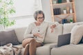 Photo of adorable sweet elderly lady wear white cardigan talking modern gadget indoors apartment room