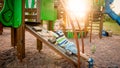 Photo of adorable toddler boy climbing and crawling on wooden staircase on children palyground at park