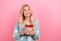 Photo of adorable woman with wavy hairdo dressed print cardigan eat fresh strawberry at grocery market isolated on pink Royalty Free Stock Photo