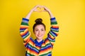 Photo of adorable young lady make hands look heart shape above head isolated on shine yellow color background
