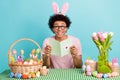 Photo advertisement celebrate easter spring holiday concept young guy wear bunny ears reading postcard greetings