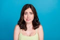 Photo of afraid guilty girl dressed green clothes biting lip empty space isolated blue color background Royalty Free Stock Photo