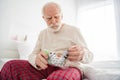 Photo of aged man pensioner unhappy unwell unhealthy ill look meds pills painkiller sit bed home indoors