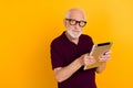 Photo of aged man use tablet think dream idea look empty space isolated over yellow color background