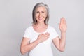 Photo of aged woman happy positive smile hold hand make promise oath swear tell truth isolated over grey color