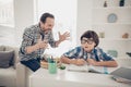 Photo of aggressive dad screaming at his small son who does not understand the material and home task he is very Royalty Free Stock Photo