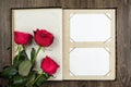 Photo album and roses on wood background Royalty Free Stock Photo