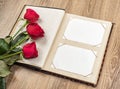 Photo album and roses on wooden Royalty Free Stock Photo