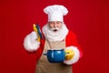 Photo of amazed santa claus open pot cover saucepan x-mas overcooked dinner wear cahef cap red apron isolated bright Royalty Free Stock Photo