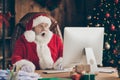 Photo of amazed santa claus sit table desk work computer impressed many wish gift list letters in house idnoors with