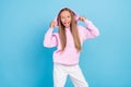 Photo of amazed shocked young little girl wear hold hands hoodie enjoy good mood blue color background Royalty Free Stock Photo