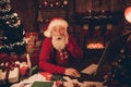 Photo of amazed speechless santa claus take pc delivery order wear hat sweater in north pole office indoors
