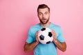 Photo of amazed surprised man in stupor holding soccer ball with hands loving to play football isolated pastel color Royalty Free Stock Photo