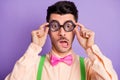 Photo of amazed surprised nerd man hold wear geek glasses wear shirt isolated on purple color background