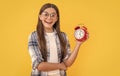 photo of amazed teen girl with alarm clock. teen girl with alarm clock  on yellow. Royalty Free Stock Photo