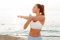 Beautiful young redhead sports woman make stretching exercise outdoors at the beach in the morning Royalty Free Stock Photo