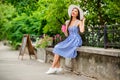 Photo of amazing lady drinking tasty coffee to-go looking up to sky in quiet park wear sun hat and striped dress Royalty Free Stock Photo