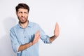 Photo of amazing multiethnic guy looking empty space with disgust stop with arms movement to him wear casual denim shirt