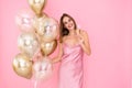 Smiling young woman holds glass of champagne and golden air balloons. came to party. Celebration Royalty Free Stock Photo
