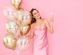 Happy young woman raises up glass of champagne holds many air balloons. came to party. Celebration Royalty Free Stock Photo