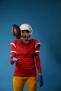 Photo of american female football player in white helmet, sportswear throwing ball Royalty Free Stock Photo