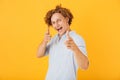 Photo of amusing handsome man 20s smiling and pointing fingers a