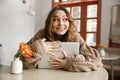Photo of amusing woman in sweater looking aside with happy smile