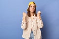 Photo of angry funny brown haired teenager girl wearing baseball cap and jacket posing isolated over blue background, arguing with Royalty Free Stock Photo