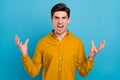 Photo of angry furious guy scream open mouth raise hands wear yellow shirt isolated blue color background